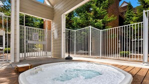 A hot tub on a wooden deck with a white fence and a wooden house in the background. - River Glen Streamside Condo: Stroll To Main St, Shuttle Stop (Frisco)