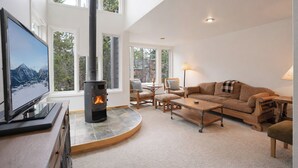 A living room with a fireplace, a television, and a sofa. - River Glen Streamside Condo: Stroll To Main St, Shuttle Stop (Frisco)