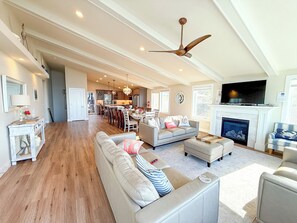 A spacious living area with a fireplace, a television, and a dining area.