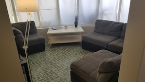 Un salon avec deux canapés, une table basse et une lampe.