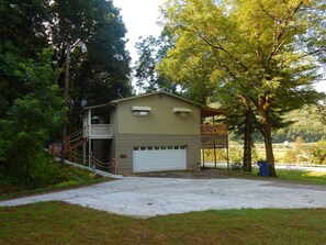 A two-story building with a garage, a covered porch, and a fenced yard.