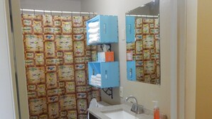 Ein Badezimmer mit Toilette, Waschbecken und blauen Stauraumelementen.