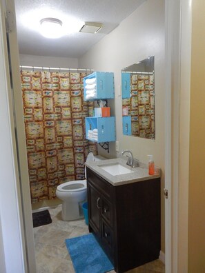 A bathroom with a toilet, sink, and blue storage units.