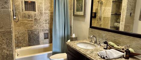 A bathroom with a bathtub, a shower, a toilet, and two sinks.