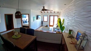 A modern kitchen with a dining area, a ceiling fan, and a large window. - Hamilton Cove ocean front luxury Villa Spectacular Views w/electric cart (Avalon)