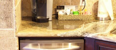A kitchen with stainless steel appliances, a coffee maker, and a paper towel dispenser.