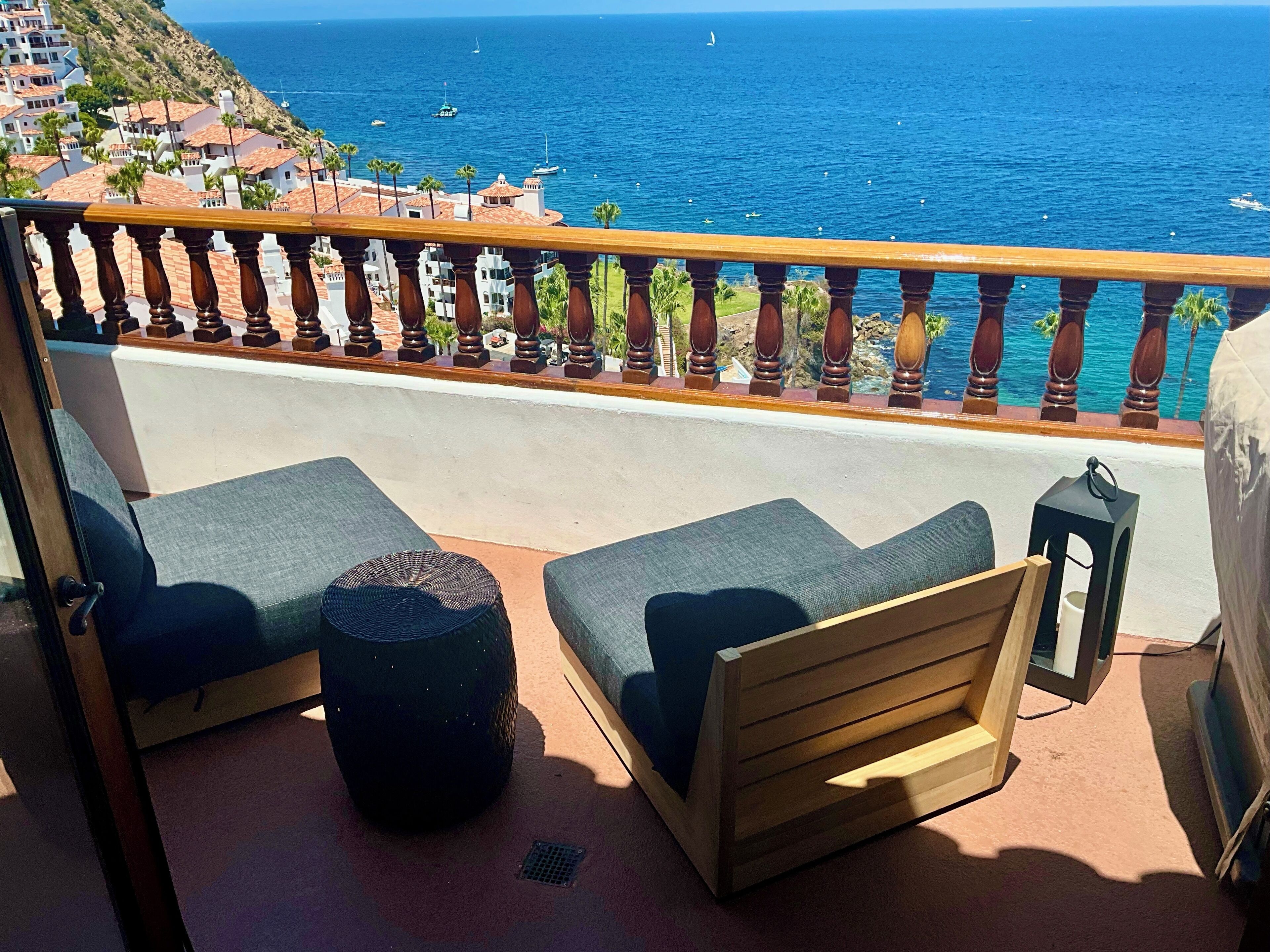 Un balcon avec des sièges d’extérieur, une vue sur la mer et une balustrade.