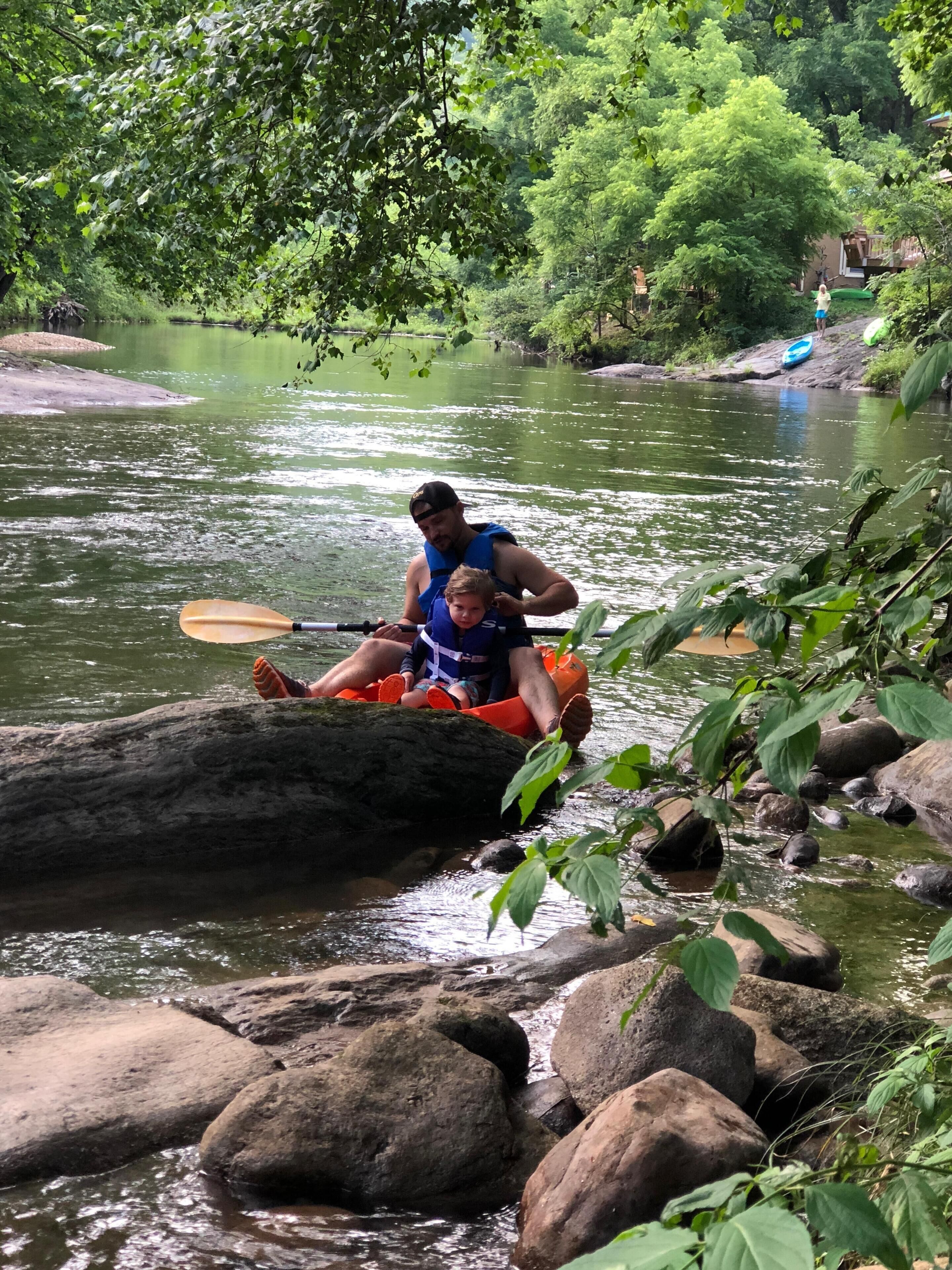 A river scene with a kayak and a person paddling.