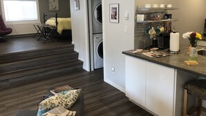A compact apartment with a laundry area, a small kitchenette, and a dining area. - Top loft garage suite close to Whyte Ave & University. Quick access to Downtown. (Edmonton)