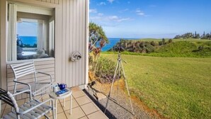 A balcony with a view of the ocean, a tripod, and a chair. - AC!! Stunning Ocean Views - Walk to the beach #133-134 (Princeville)