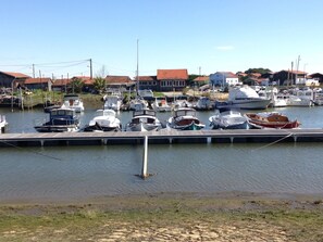 A marina with various boats docked, a wooden pier, and houses in the background. - Villa +private heated pool, quiet area, near Bassin, Special offer / 2026 (La Teste-De-Buch)