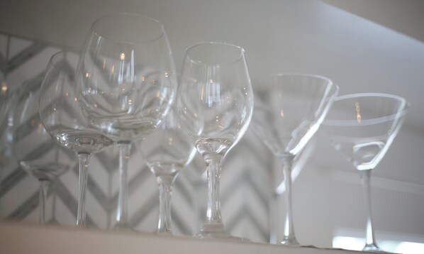 A row of clear wine glasses on a white surface. - Luxurious Harbor View “Cynthia” cottage. Walk & bike to everything! (Nantucket)