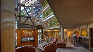 A spacious lobby with leather seating, a staircase, and a sign for 'Silver King'. - Highly Rated Silver King - Steps to Skiing - 2BD/2BA (Park City)