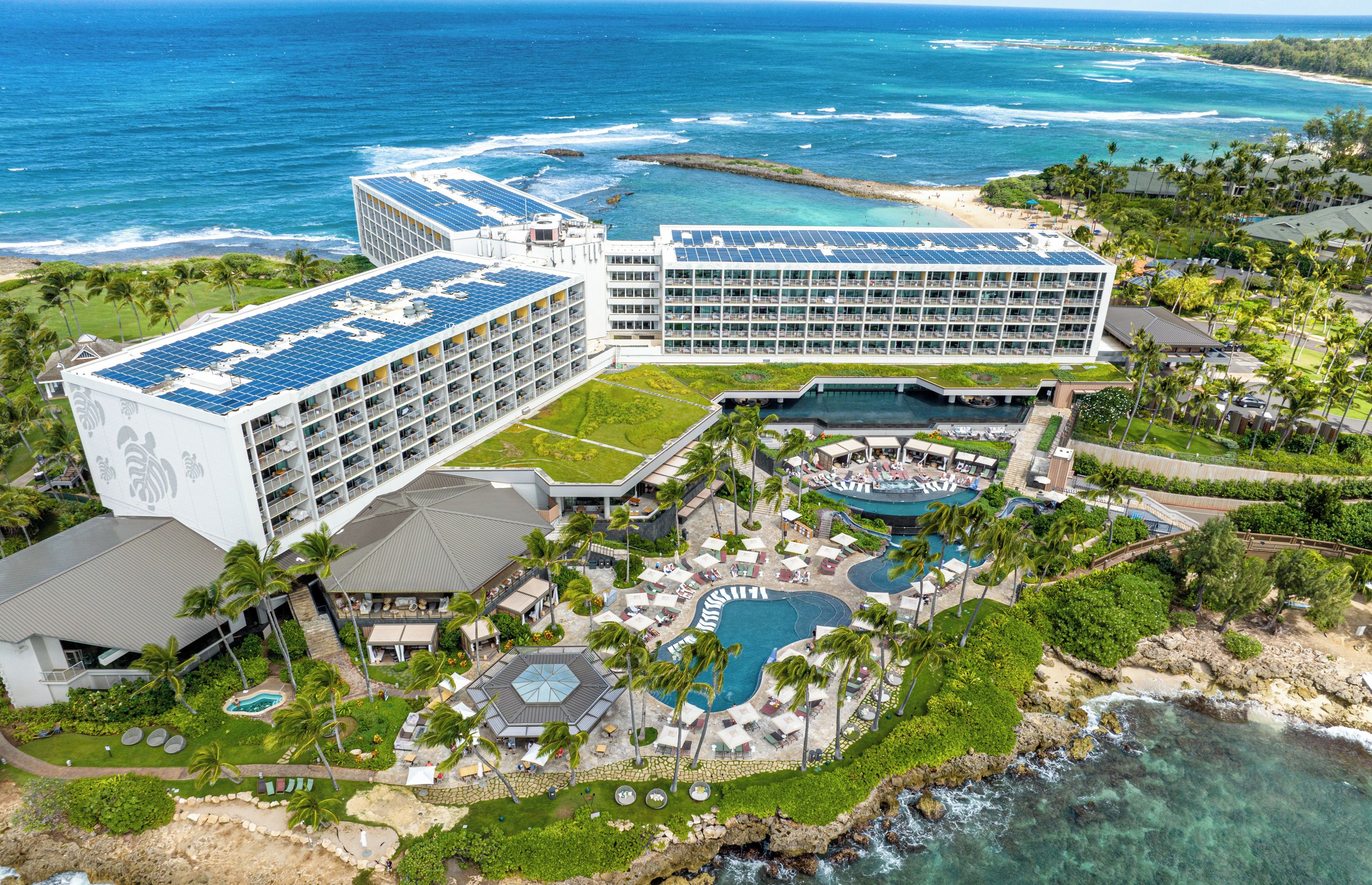 A resort with multiple buildings, a pool area, and a beach.