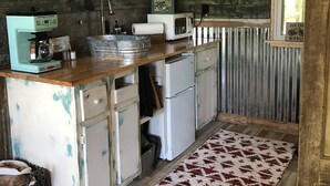 Une cuisine rustique avec des meubles en bois, une machine à café, un grille-pain et un réfrigérateur.
