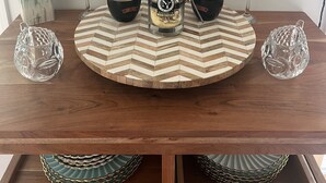 Ruokapöytä, jonka päällä on tequila-pullo, kaksi lasia ja koristeellinen lautanen.