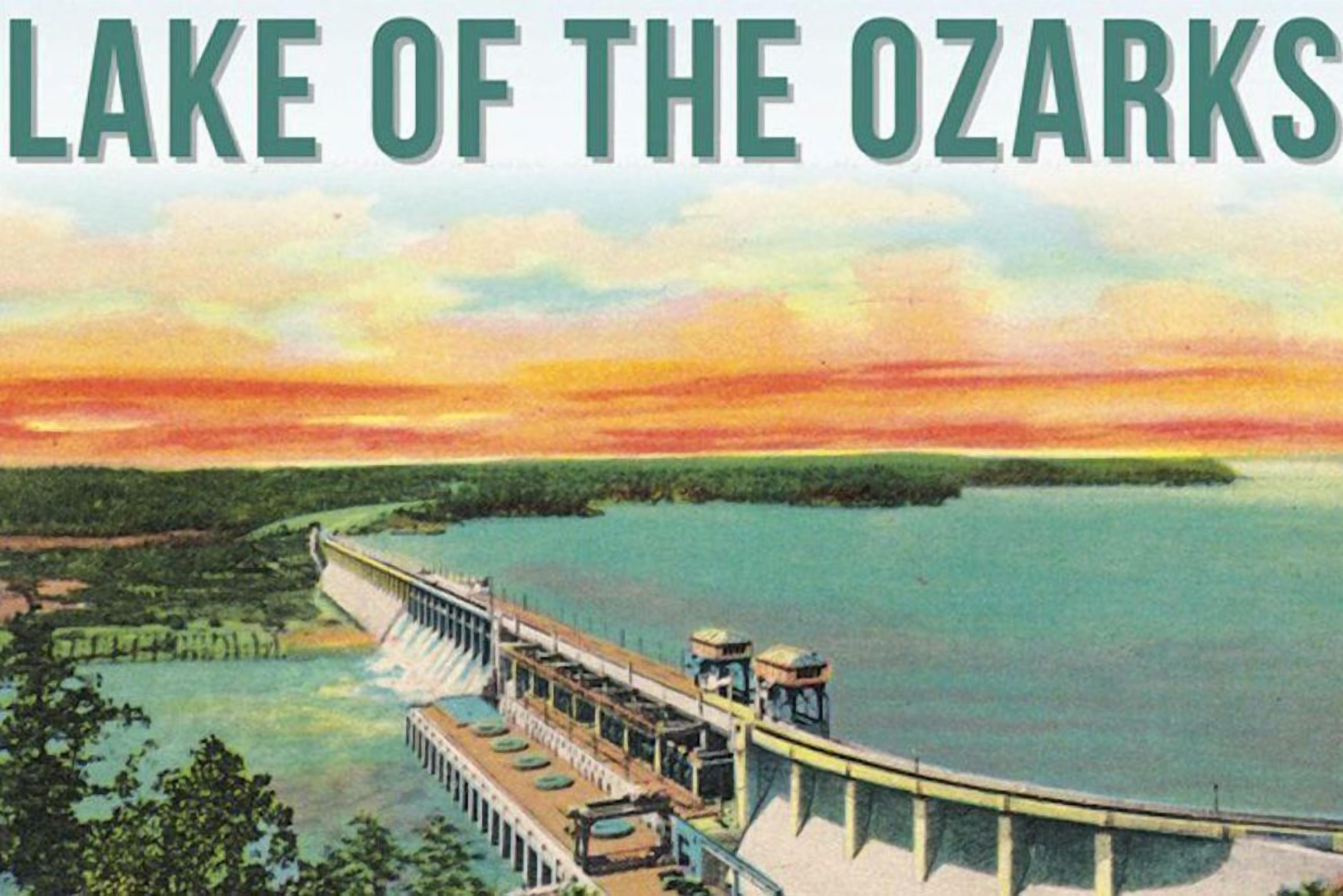 A large dam with a bridge over a calm lake, surrounded by greenery.