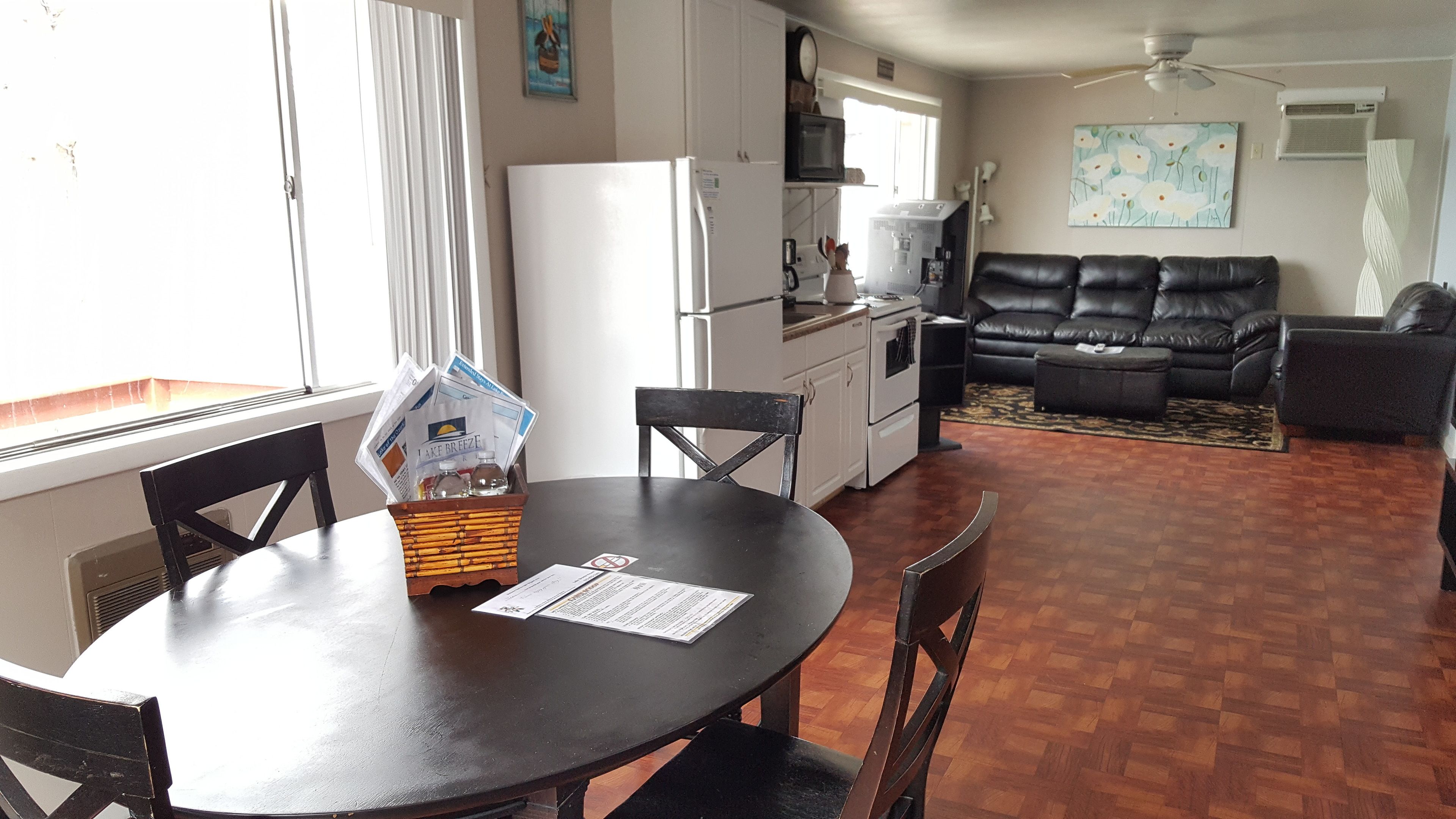 A compact living space with a dining table, chairs, a sofa, and a kitchen area.