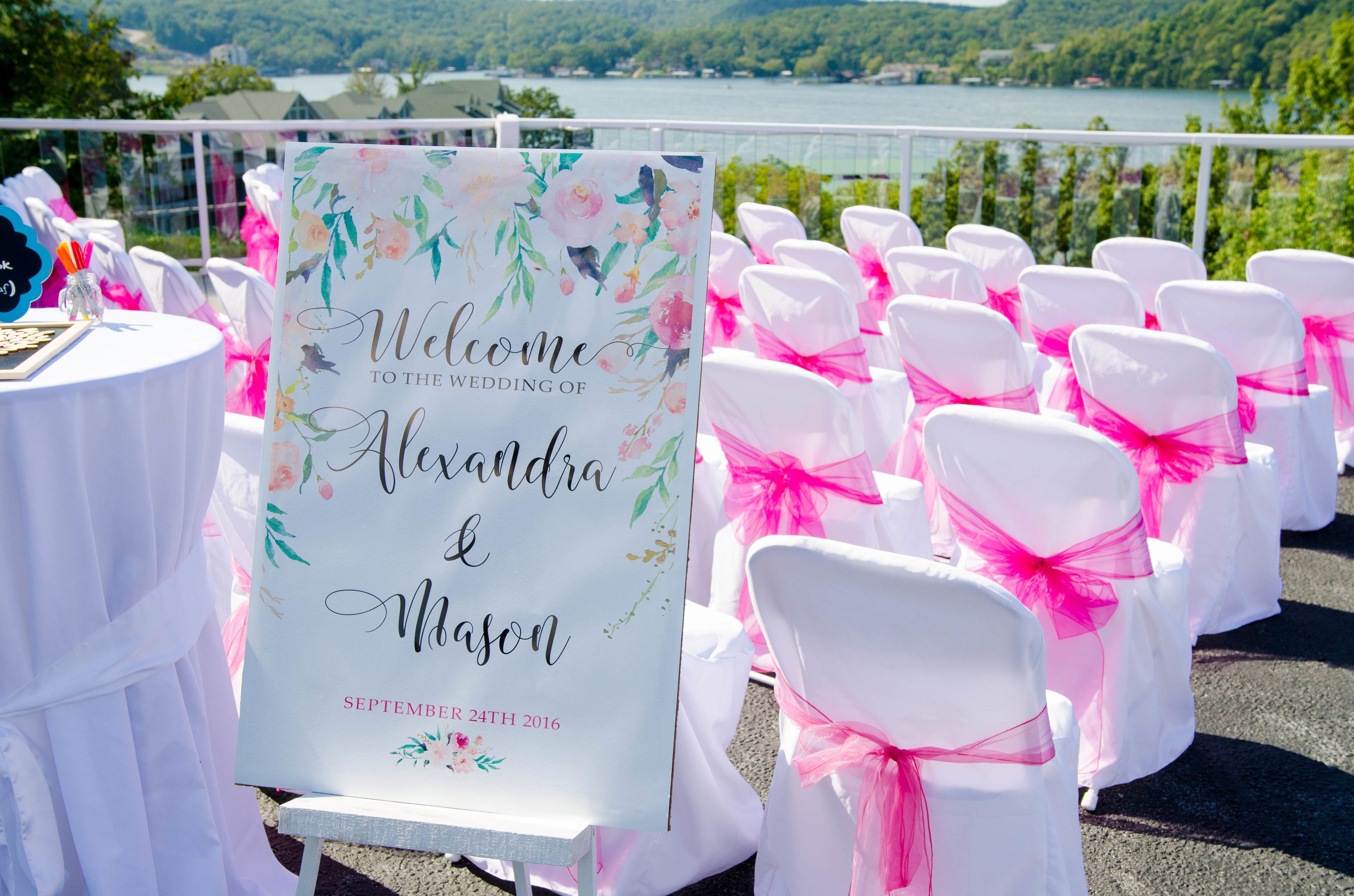 Señal de boda con decoración floral y vistas a un lago.