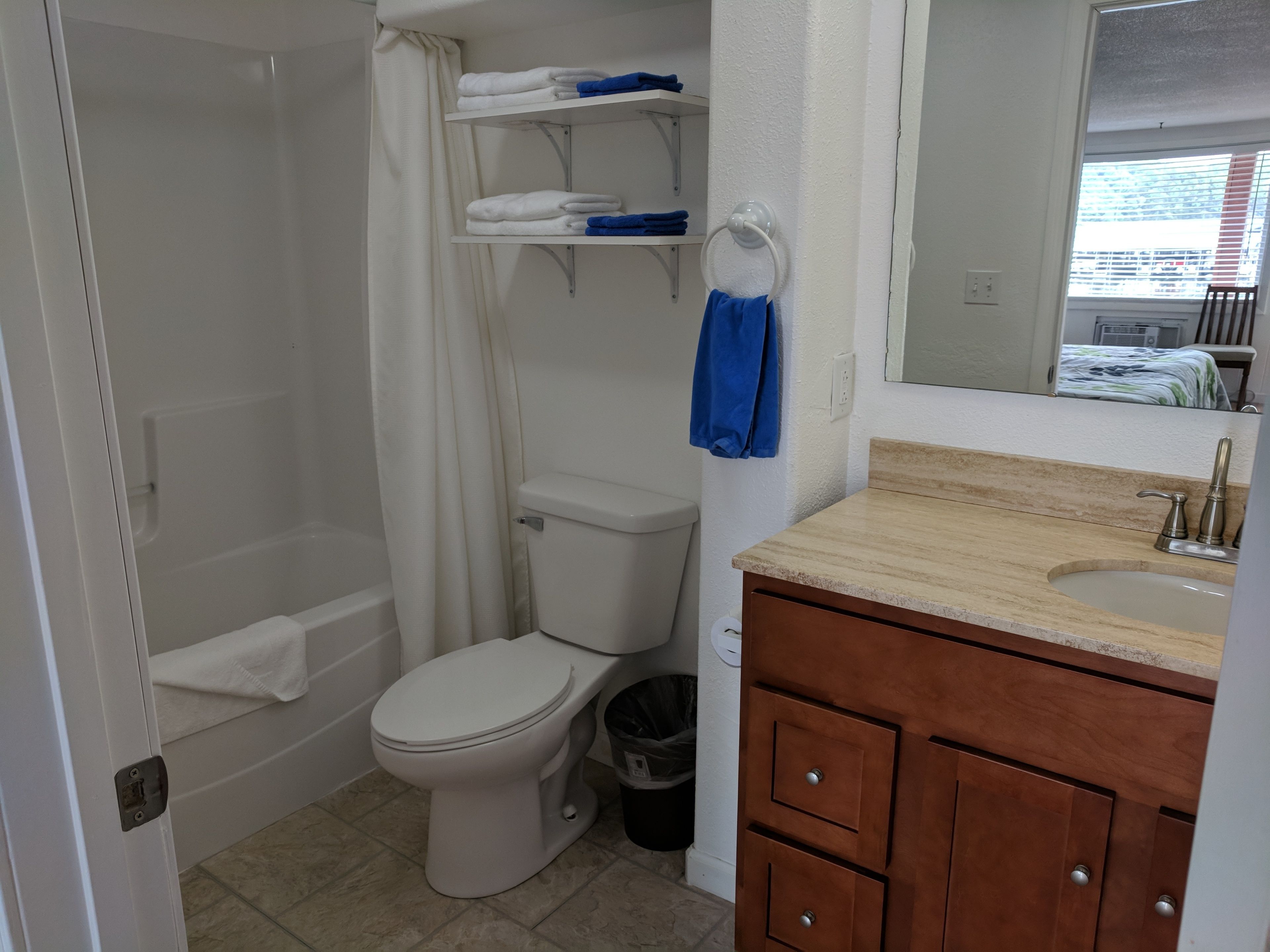A bathroom with a toilet, shower, and vanity with a sink.