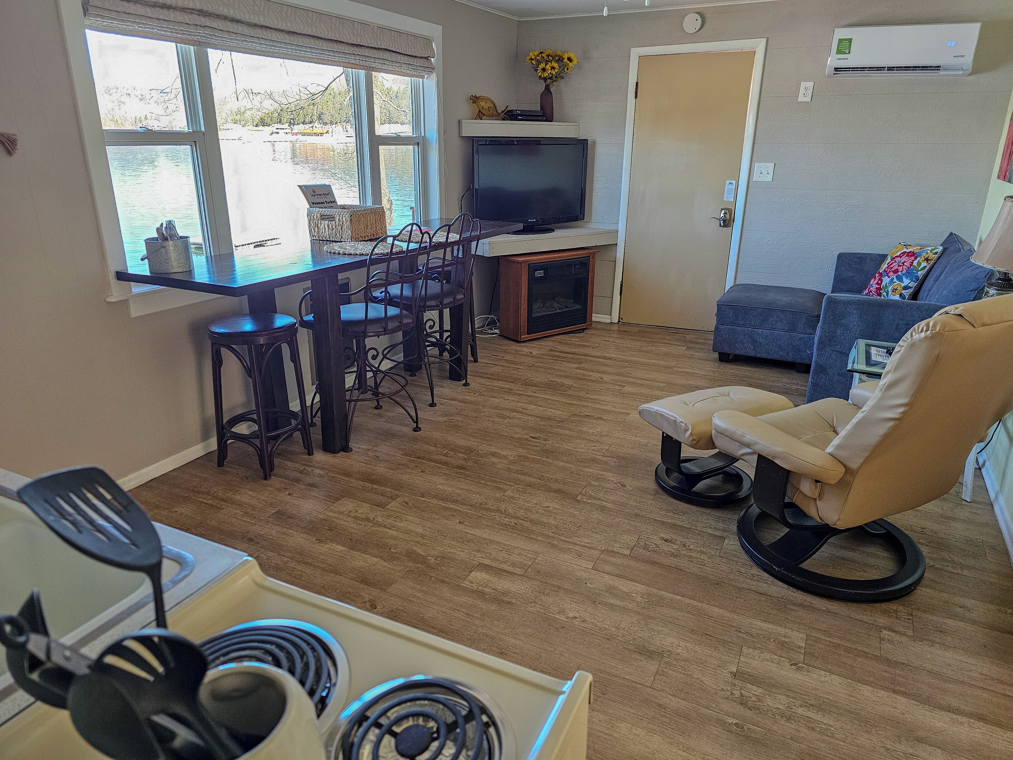 A compact living space with a dining area, a sofa, a TV, and a kitchenette.