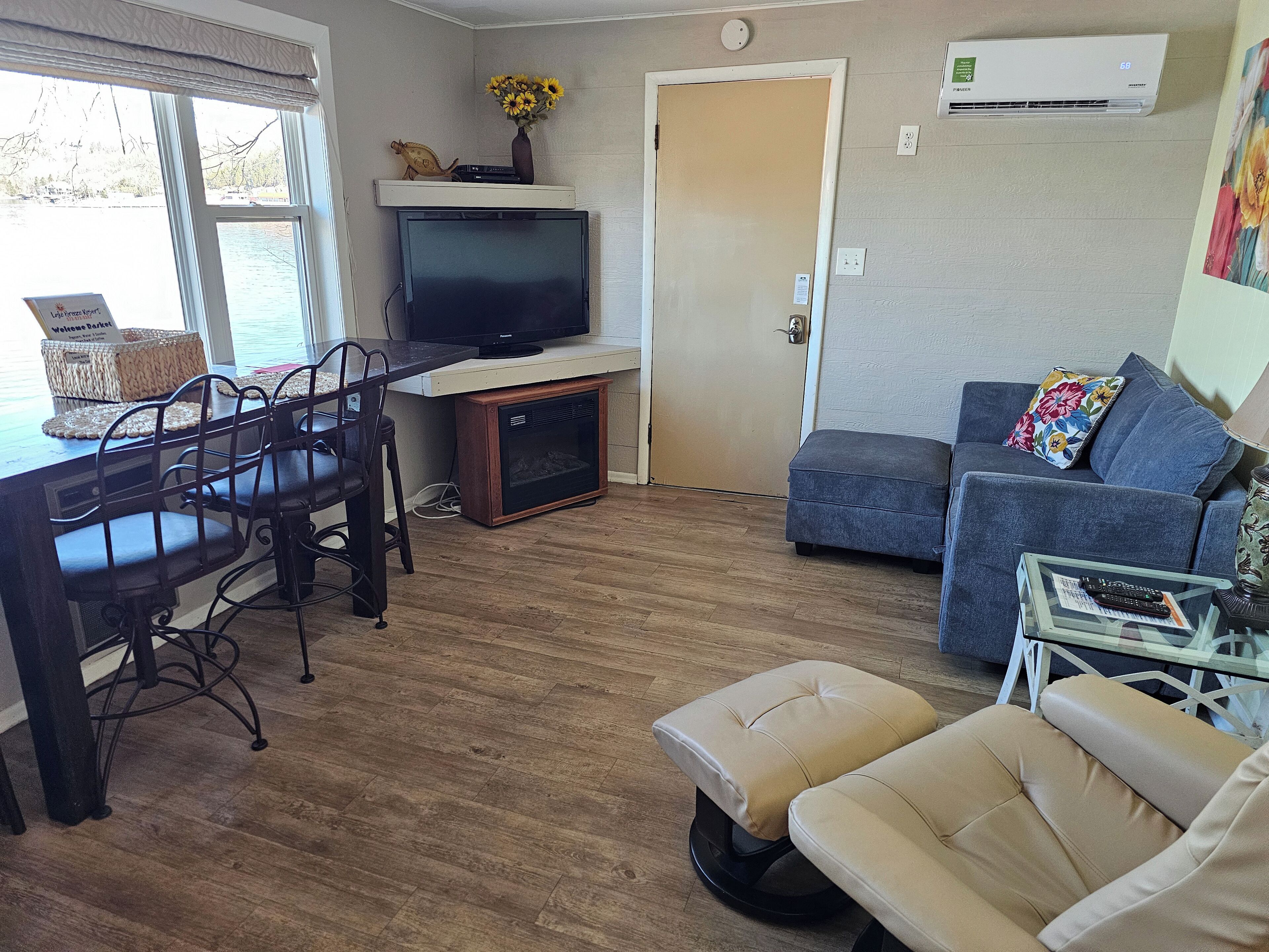 A compact living space with a dining area, a sofa, and a television on a stand.