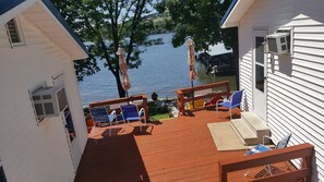 A deck with outdoor seating and a view of a lake. - Lake Breeze Resort  (Camdenton)