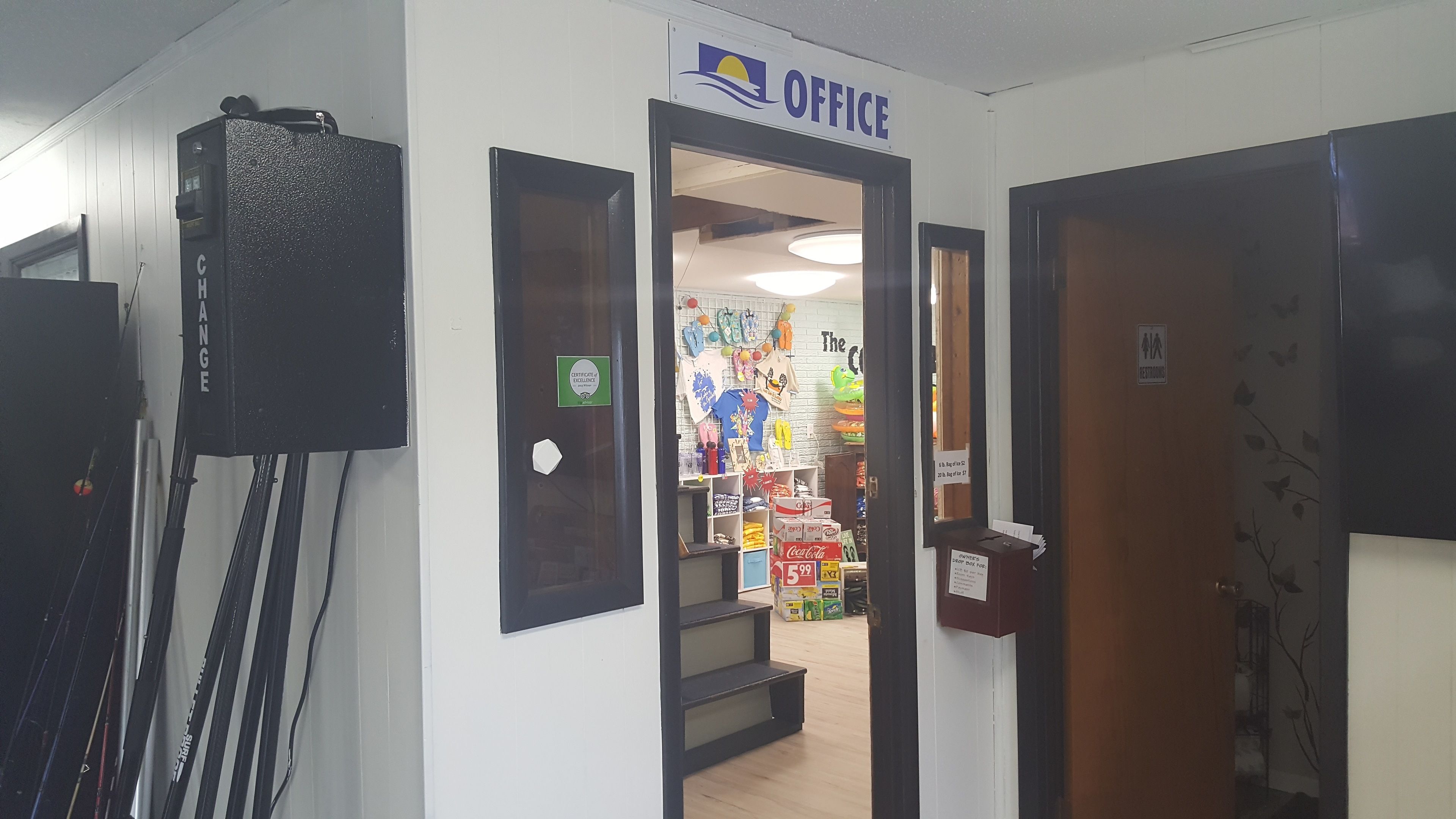 Un ufficio con un cartello sopra la porta, una macchina distributrice e un espositore con diversi articoli.