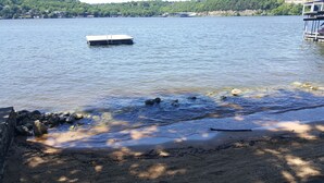 A lake with a dock and a rocky shoreline. - Lake Breeze Resort  (Camdenton)