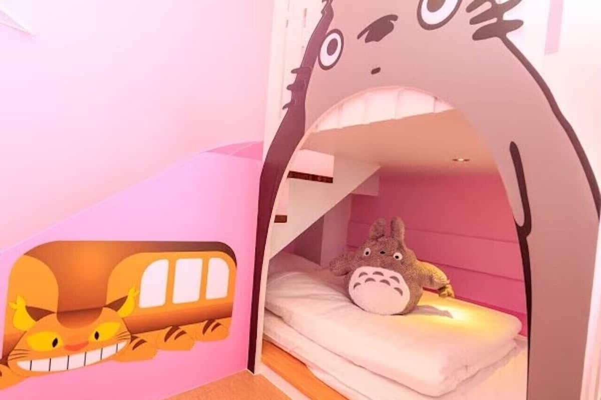 A children's bunk bed with a cartoon character window and a stuffed toy on the bed.