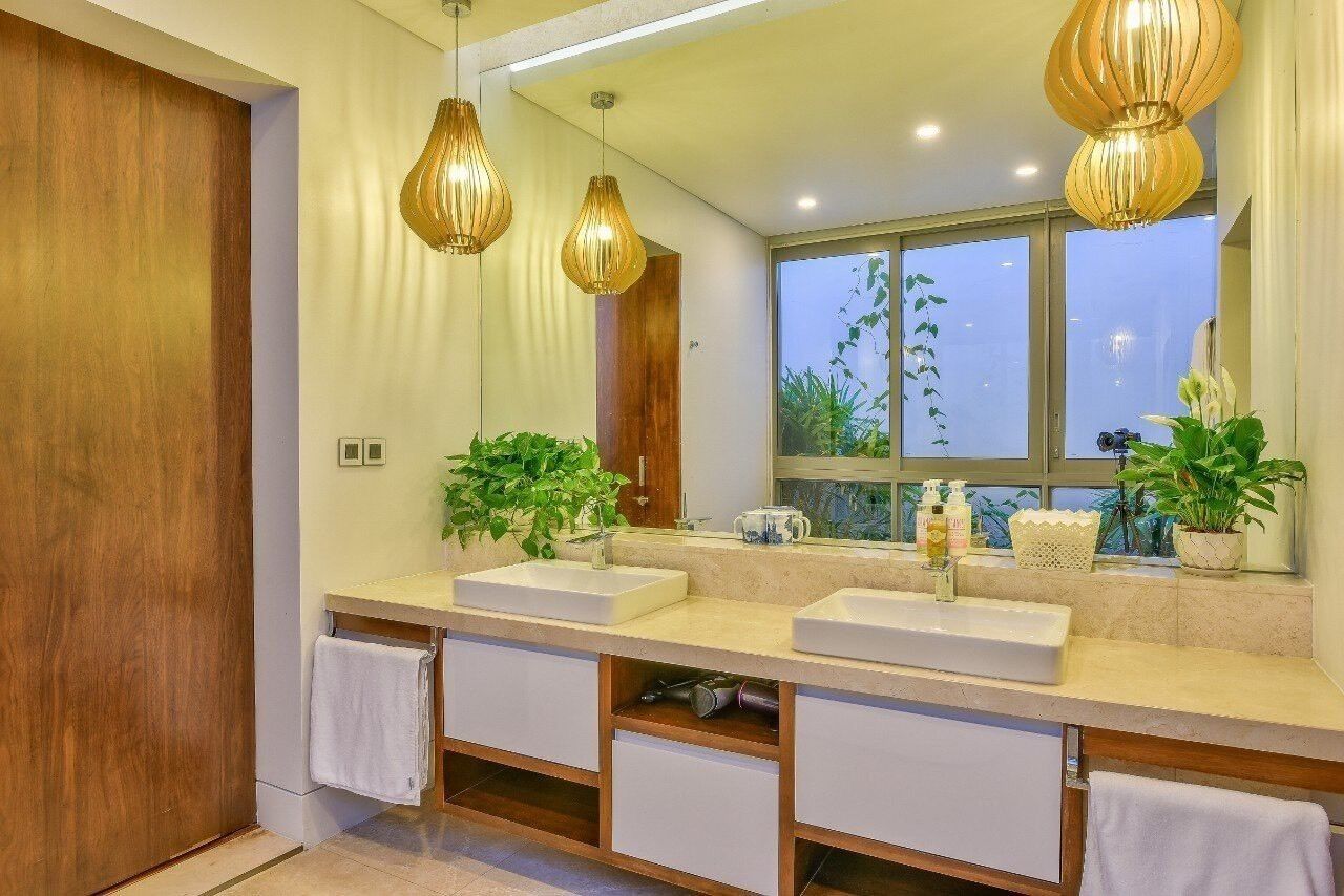 A modern bathroom with two sinks, wooden cabinets, and a large mirror.