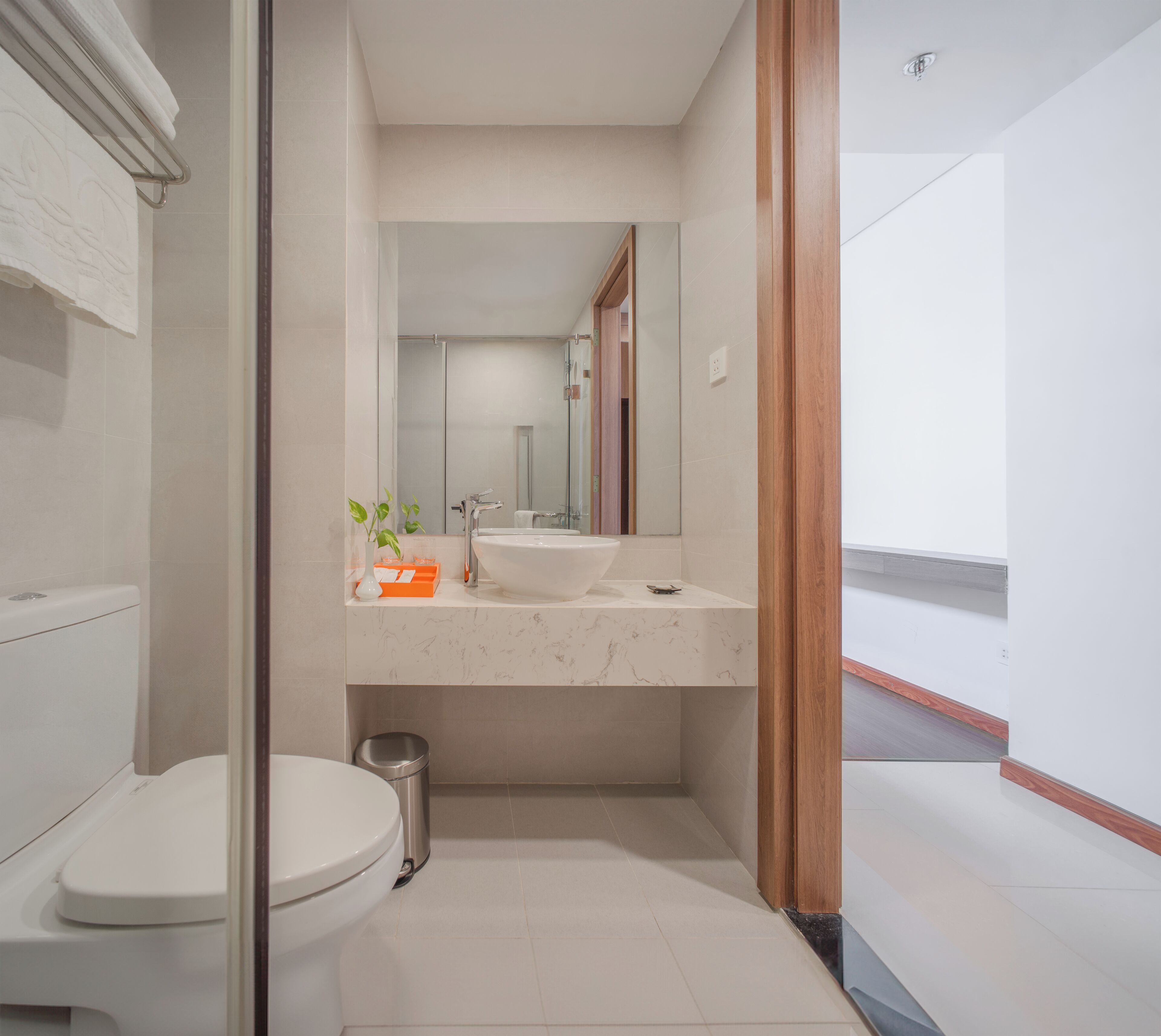 Een moderne badkamer met toilet, wastafel en spiegel.