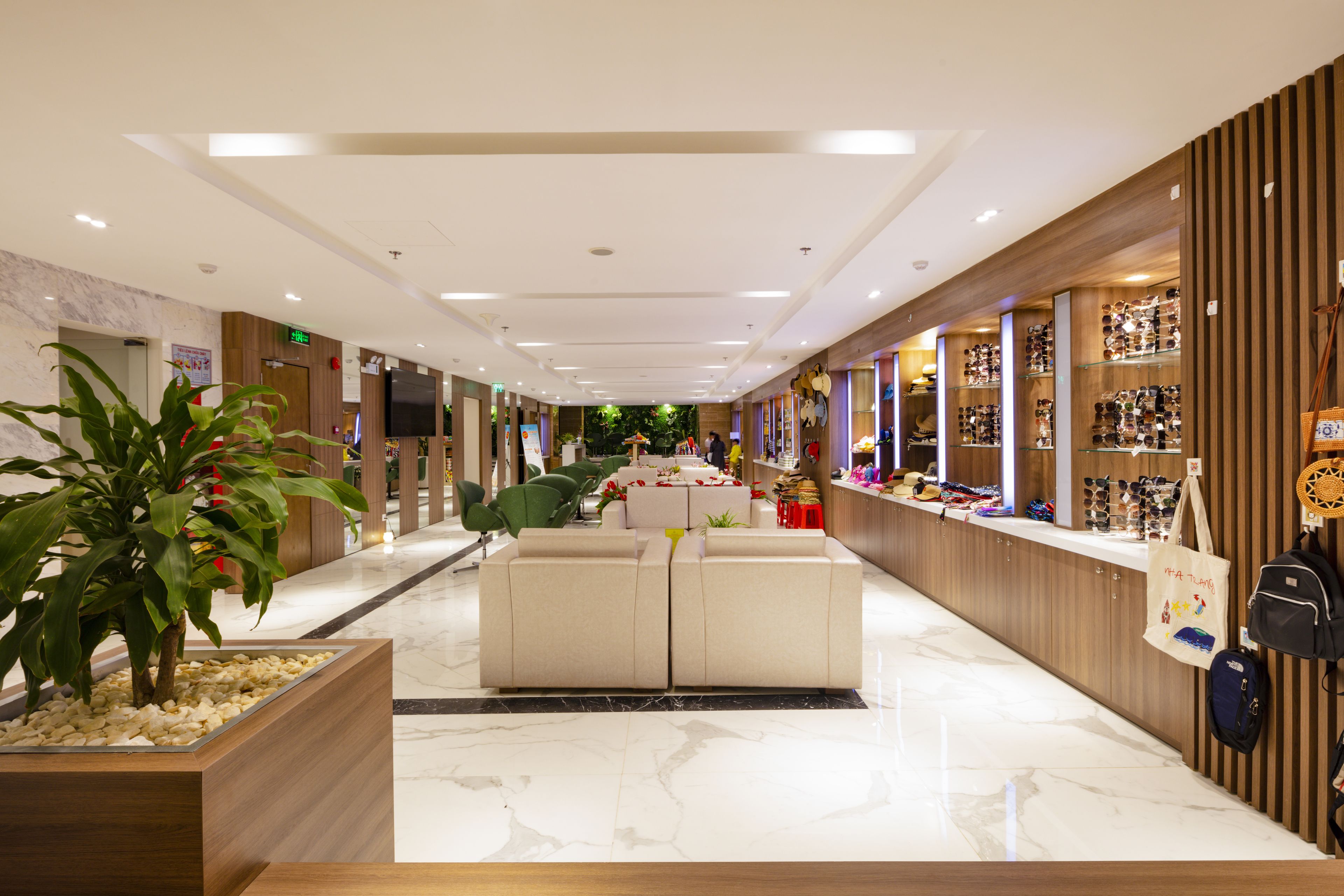 Un hall d’hôtel comprenant un comptoir d’accueil, un espace salon et un présentoir à chaussures.