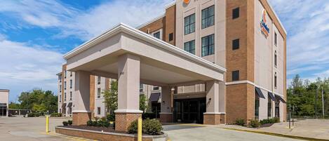 A Comfort Suites hotel with a covered entrance, brick facade, and a parking lot.