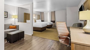 A hotel room with a bed, two bedside tables, a desk, a chair, a sofa, and a small ottoman. - Comfort Suites Columbia I-65 (Columbia)