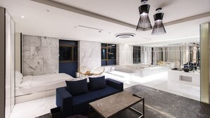 Un moderno hall de hotel con un sofá, una mesa de centro y una zona de estar con sillones.