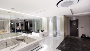 Un baño moderno con un espejo grande, una bañera y una zona de ducha.