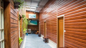 Un pasillo con paredes de madera, un banco y una puerta.