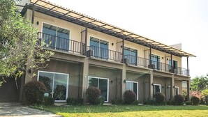 Un immeuble résidentiel à plusieurs étages, doté d’un toit plat, de grandes fenêtres et d’un balcon couvert.