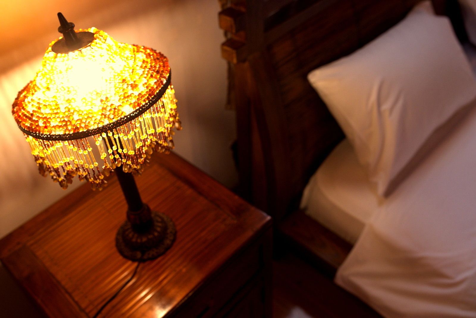 Ein Nachttisch aus Holz mit einer dekorativen Lampe.