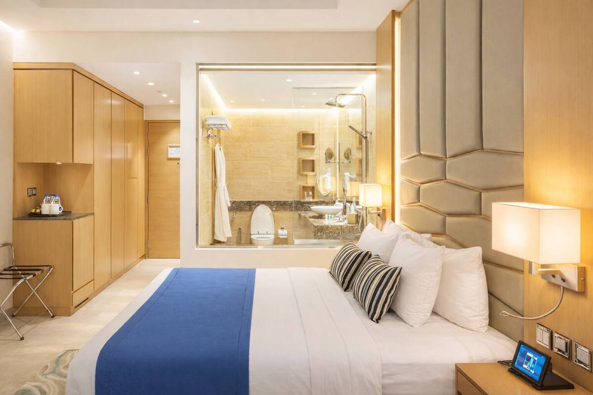 Ett modernt hotellrum med en stor säng, ett skrivbord och utsikt över badrummet.