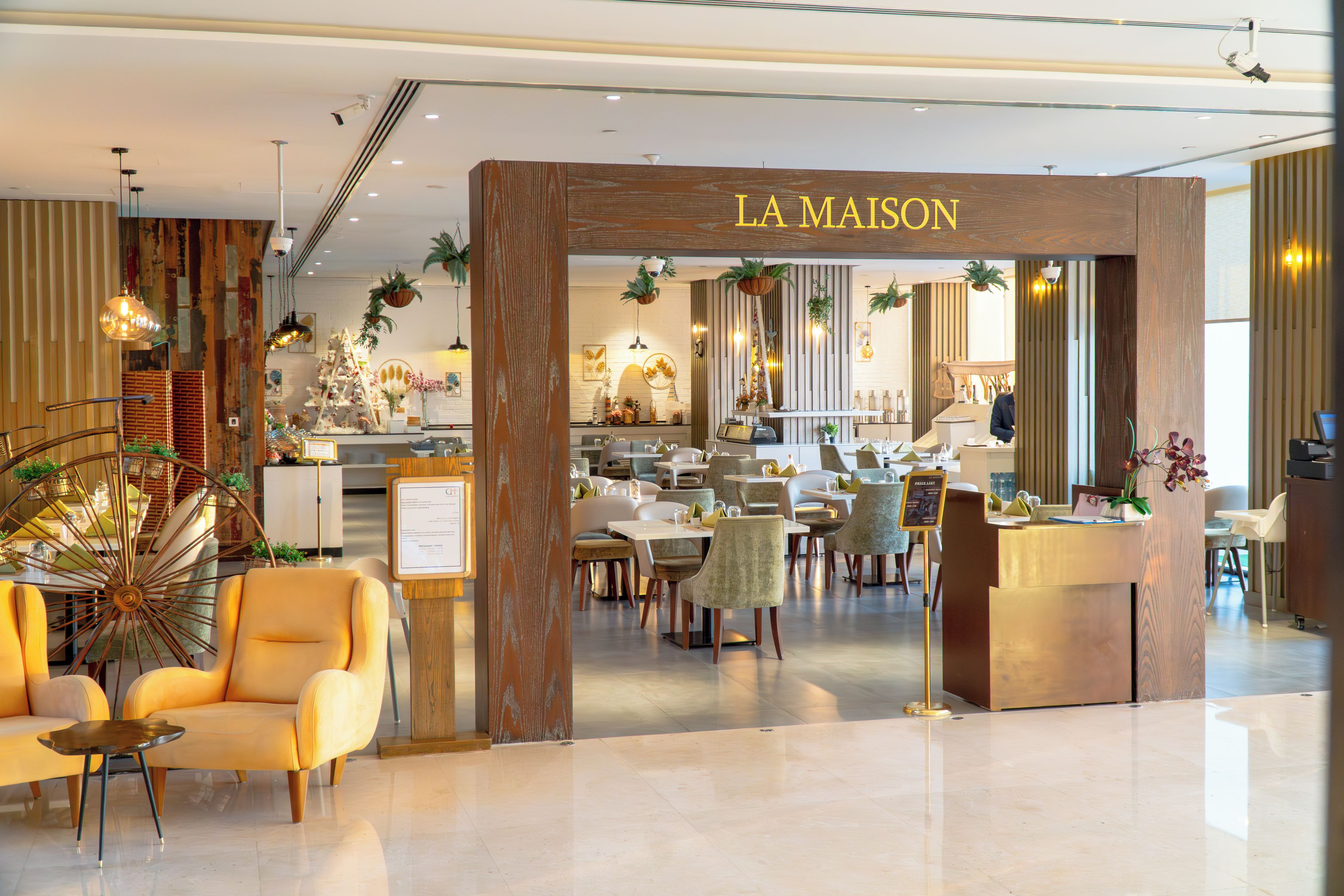 A hotel lobby with a reception desk, seating area, and a dining section.