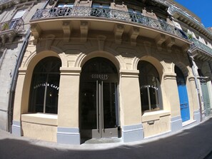 A building with arched windows and a sign reading "George's Hostel & Cafe". - Georges Hostel & Café (Sète)