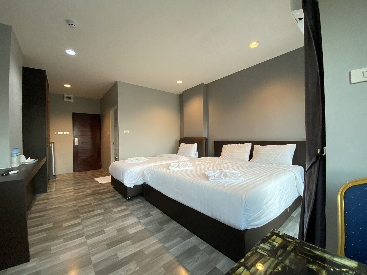 A hotel room with a large bed, a desk, and a chair.