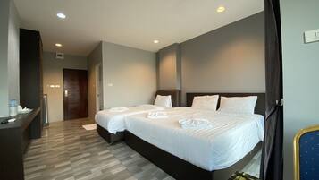 A hotel room with a large bed, a desk, and a chair.