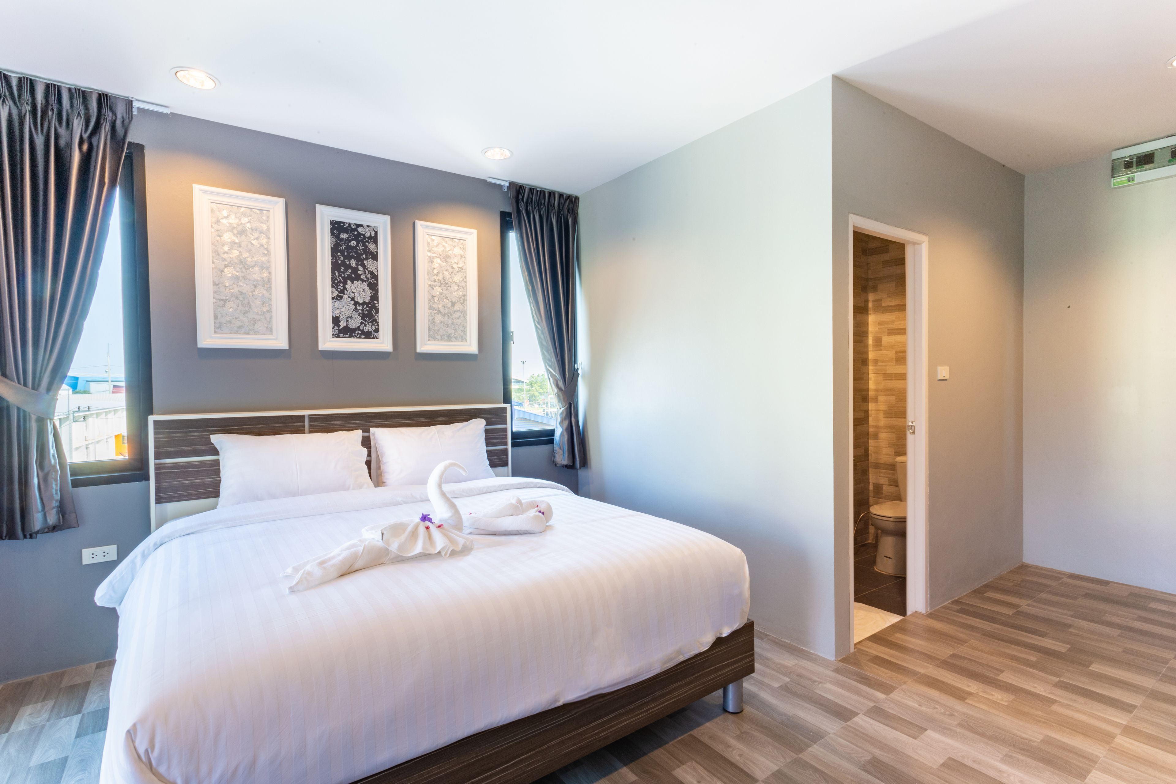 Habitación de hotel moderna con una cama grande, una obra de arte enmarcada en la pared y vistas al exterior por la ventana.