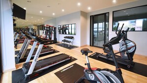 A gym with treadmills, elliptical machines, and weightlifting equipment. - Grand Inter Hotel (Samut Sakhon)