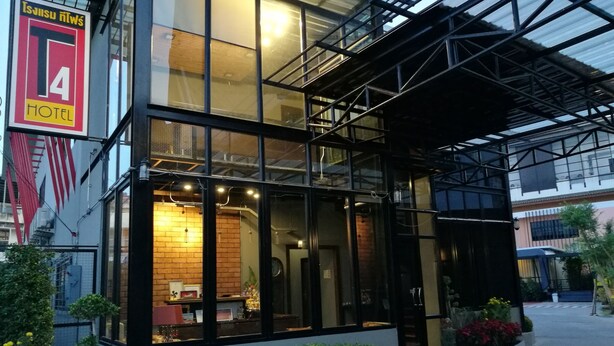 Un hotel moderno con fachada de vidrio, una recepción visible y un cartel que indica que es un hotel de 4 estrellas.