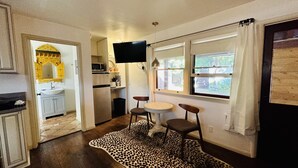 A compact kitchen with a microwave, sink, and a small dining area with a table and chairs.