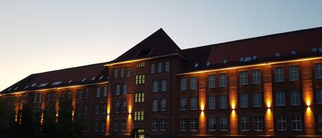 A large brick building with multiple windows and a prominent entrance.